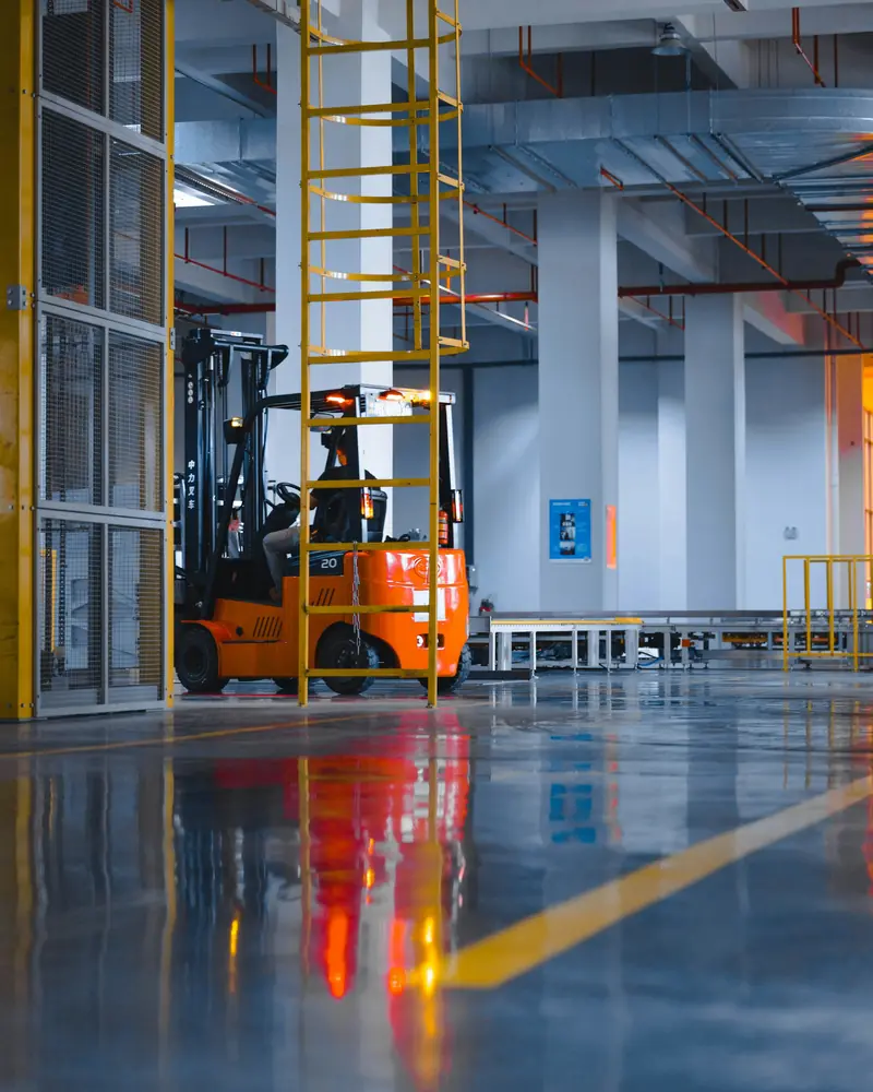 Forklift inside a large, brightly lit warehouse
