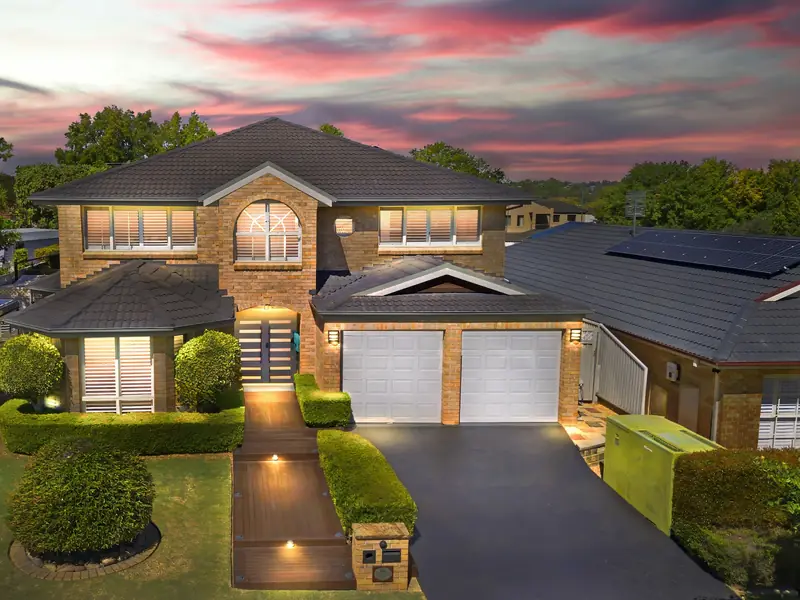 Two-storey brick home in a Sydney-style suburb at dusk, with rooftop solar on the house next door
