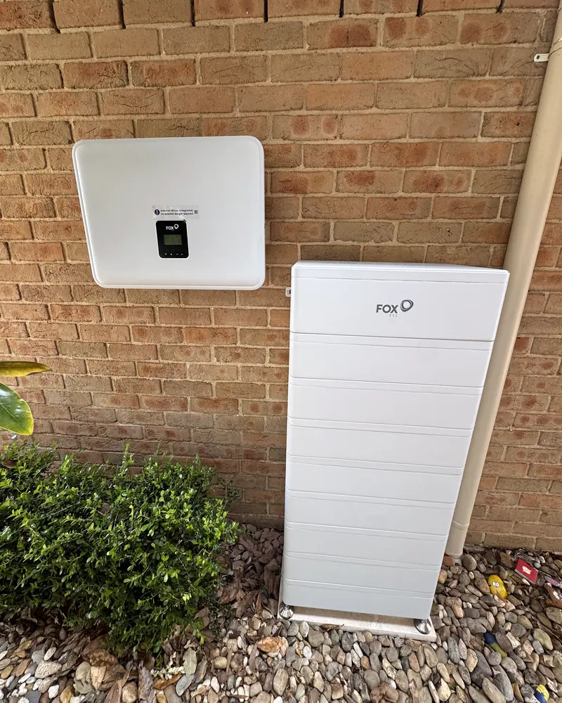 Hybrid inverter and stacked home battery on a brick wall: a real install by New Day Energy